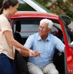 Let me help you out of the car. Shot of a woman helping her senior father out of the car.